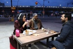 Amani Al-Khatahtbeh, founder of MuslimGirl.com, left, sips a soda while talking with old friends Mohammed Ali, right, and Saad Khan outside of a corner market in the Brooklyn borough of New York, Dec. 27, 2019.