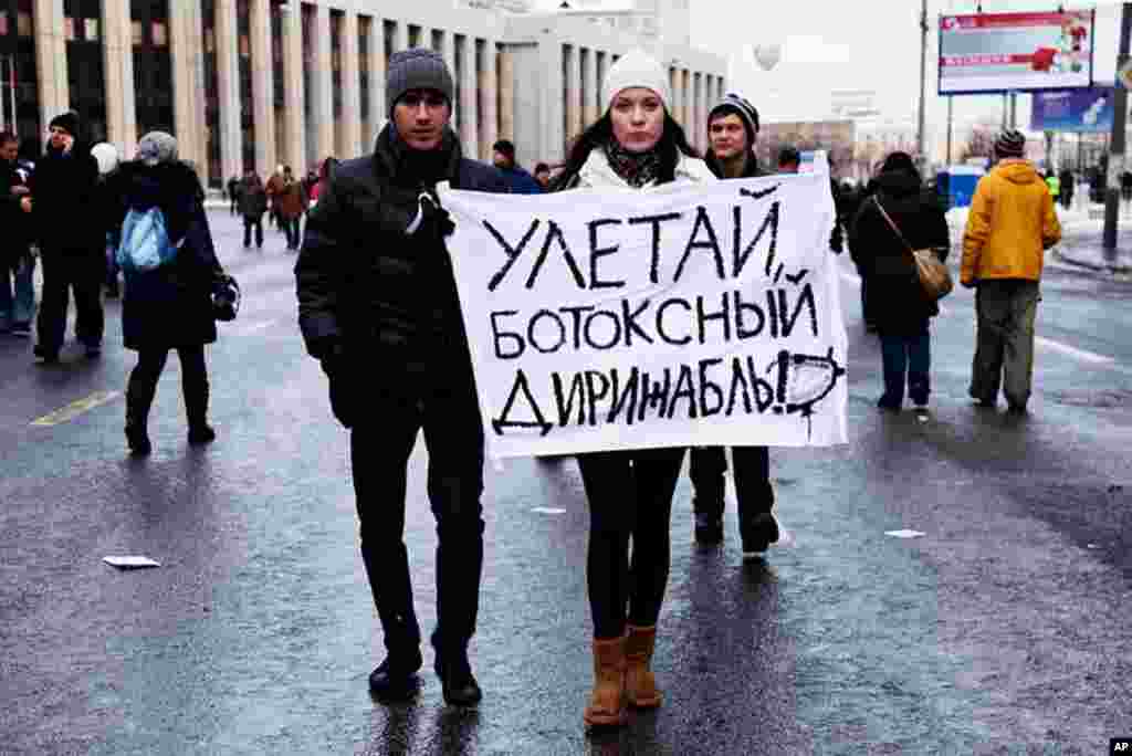 Young protesters hold a sign that reads, "Fly away Botox blimp," a reference to rumors that Prime Minister Vladimir Putin uses Botox to appear younger, December 24, 2011. (VOA - Y. Weeks)