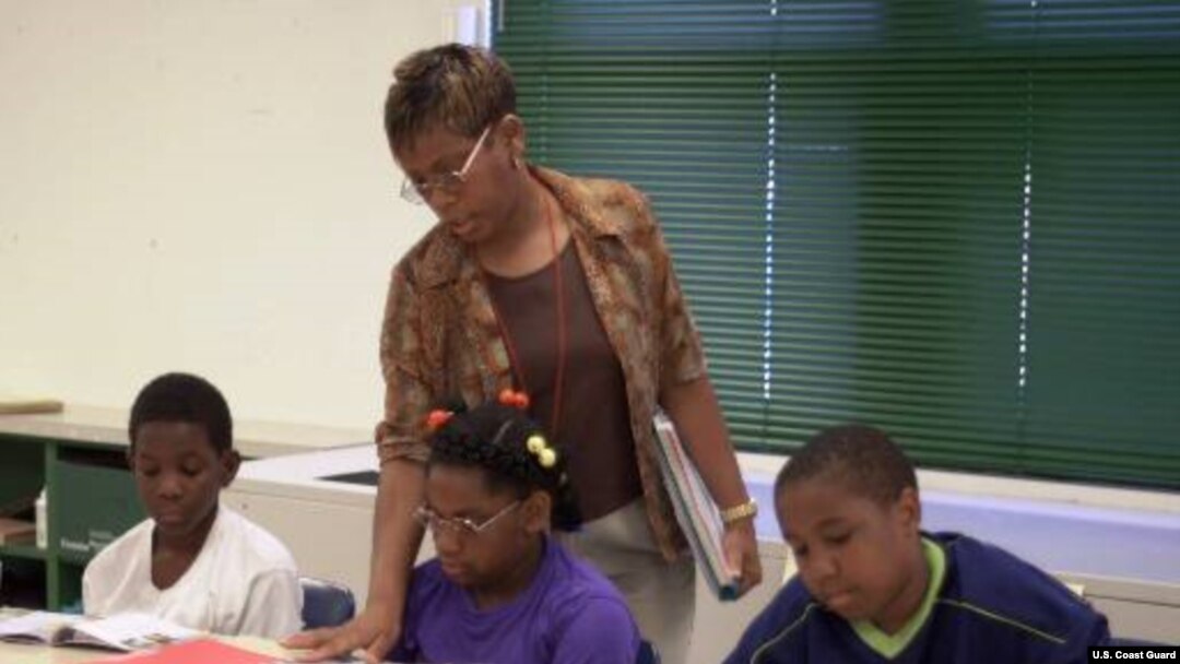 Guru kelas empat Minyon Cantey sedang mengajar David Burrell, 9, kiri, Shalise Allison, 11, tengah, dan Jeffrey Barham, 11, pelajaran seni berbahasa dalam program sekolah musim panas di SD Arlington di Baltimore, Negarabagian Maryland (foto: Dok). 