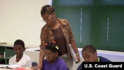 Guru kelas empat Minyon Cantey sedang mengajar David Burrell, 9, kiri, Shalise Allison, 11, tengah, dan Jeffrey Barham, 11, pelajaran seni berbahasa dalam program sekolah musim panas di SD Arlington di Baltimore, Negarabagian Maryland (foto: Dok). 