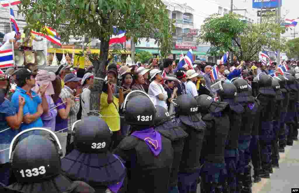 Thai anti government protesters rally next to riot policemen during the registration of constituency candidates in Nakhon Si Thammarat, Dec. 28, 2013.