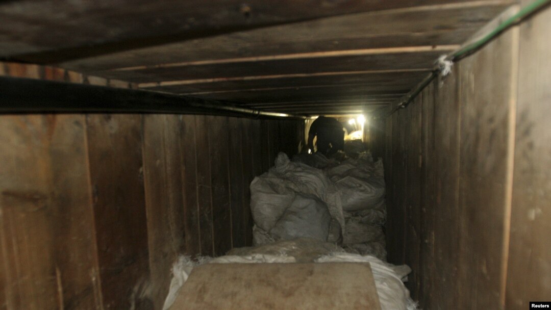 Seorang wartawan harus merangkak untuk memasuki terowongan lintas perbatasan di sebuah gudang di Tijuana (12/7). Pemerintah Meksiko telah menyita lebih dari 40 ton ganja dari dalam terowongan sepanjang 350 meter menuju San Diego, California ini. 