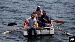 Seven men trying to migrate illegally to the United States on a raft are stopped by Cuba's Coast Guard near Havana, June 4, 2009.