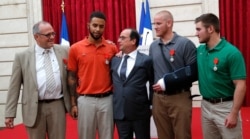 FILE - Then-French President ollande poses with British businessman Chris Norman, US student Anthony Sadler, US Airman First Class Spencer Stone and US National Guardsman Alek Skarlatos (R) during a ceremony at the Elysee Palace, Aug. 24, 2015.