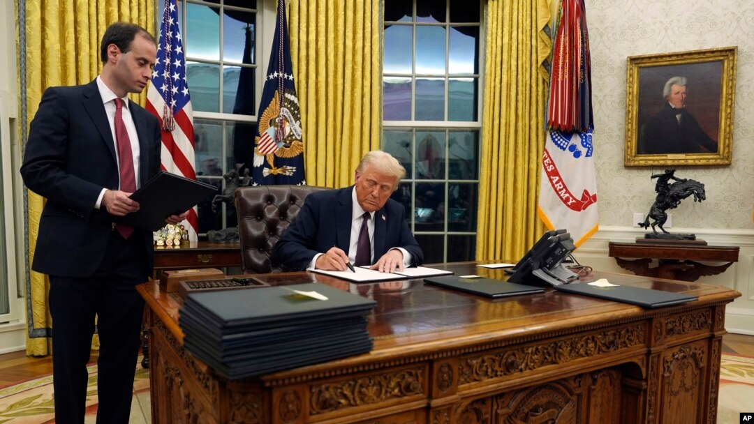 President Donald Trump signs an executive order withdrawing the U.S. from the World Health Organization in the Oval Office of the White House, Jan. 20, 2025, in Washington.