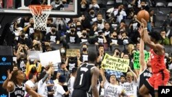 Para penonton mengenakan kaus dukungan untuk Tibet dan Hong Kong saat berlangsungnya pertandingan bola basket antara Klub Raptors (Toronto) melawan Klub Nets (Brooklyn), di New York, 18 Oktober 2019. (Foto: dok).