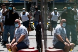 FILE - People wear masks to prevent the spread of coronavirus, as the delta variant has led to a surge in infections, in New York City, July 30, 2021.