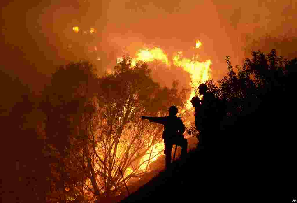 Firefighters battle a wind-driven brush fire in Simi Valley, California, USA. Strong Santa Ana winds spread the fire quickly, however, firefighters gained the upper hand in several hours after using water dropping helicopters, engines, and hand crews.