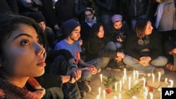 Young people gather around candles as they begin three days of mourning Friday to mourn dozens who died in the protests that drove their autocratic leader from power, in Tunis, January 22, 2011