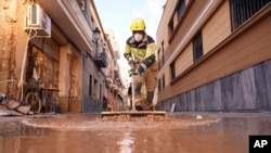 Un bombero barre el barro tras las inundaciones en Paiporta, España, el jueves 7 de noviembre de 2024.