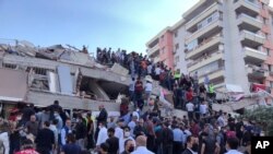 30일 터키 이즈미르 시에 규모 7의 강한 지진이 강타해 건물이 붕괴된 사고현장에서 구조대원들이 생존자를 수색하고 있다. 