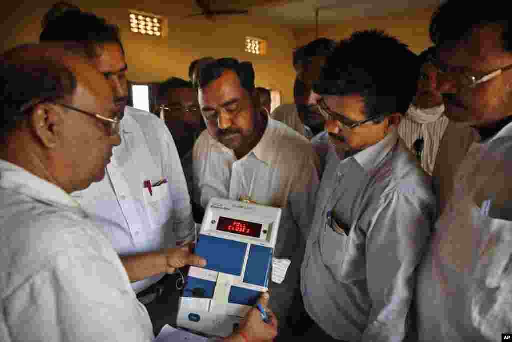 Indian election officials seal an electronic voting machine after the closing of a polling center in Kunwarpur village, Uttar Pradesh state, India, May 12, 2014. 