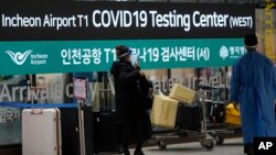 FILE - A woman arriving from China enters a COVID-19 testing center at the Incheon International Airport In Incheon, South Korea, Thursday, Jan. 5, 2023. 