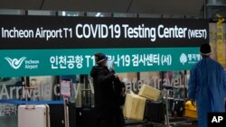 FILE - Pendatang dari China memasuki pusat pengujian COVID-19 di Bandara Internasional Incheon, Korsel, Kamis, 5 Januari 2023. China menangguhkan visa bagi warga Korsel yang datang ke negara tersebut untuk wisata atau bisnis, Selasa, 11 Januari 2023. (AP/Lee Jin-man, File)