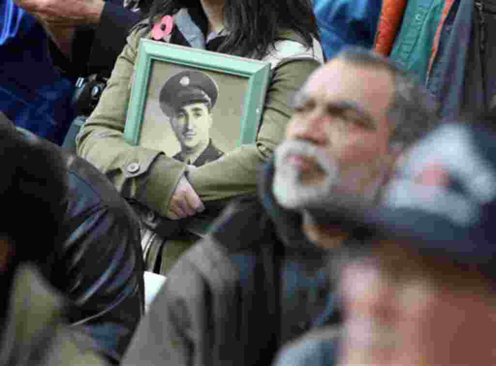 Sarah Nesbitt sostiene un retrato de su padre Murray Nesbitt, quien luchó en Inglaterra y Alemania durante la II Guerra Mundial.