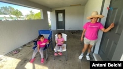 Elizabeth junto a sus dos hijas en el portal de su casa en Fort Myers, Florida, horas después del paso del huracán Milton.