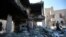 People inspect the wreckage of buildings that were damaged by Saudi-led coalition airstrikes, in Sanaa, Yemen, Tuesday, Jan. 18, 2022.