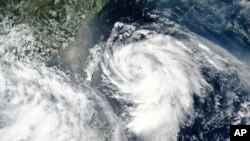 Gambar satelit yang dirilis oleh NASA menunjukkan Topan Hagupit mendekati Taiwan, tengah kiri, Minggu, 2 Agustus 2020. 