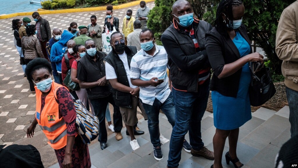 FILE - People wait to register for the first injection of the Oxford/AstraZeneca COVID-19 vaccine during the launch of a vaccination campaign, at the Kenyatta International Convention Centre in Nairobi, Kenya, April 21, 2021.