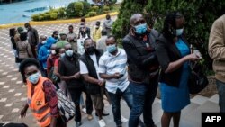 FILE - People wait to register for the first injection of the Oxford/AstraZeneca COVID-19 vaccine during the launch of a vaccination campaign, at the Kenyatta International Convention Centre in Nairobi, Kenya, April 21, 2021.