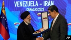 Los presidentes de Irán y Venezuela, Ebrahim Raisi y Nicolás Maduro, se estrechan las manos durante un acto oficial en Caracas, el lunes 12 de junio de 2023. Los gobernantes firmaron 25 acuerdos en distintas áreas para fortalecer sus relaciones.