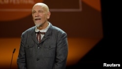FILE - Actor John Malkovich delivers a speech at the San Sebastian Film Festival in San Sebastian, Spain, Sept. 22, 2017. 