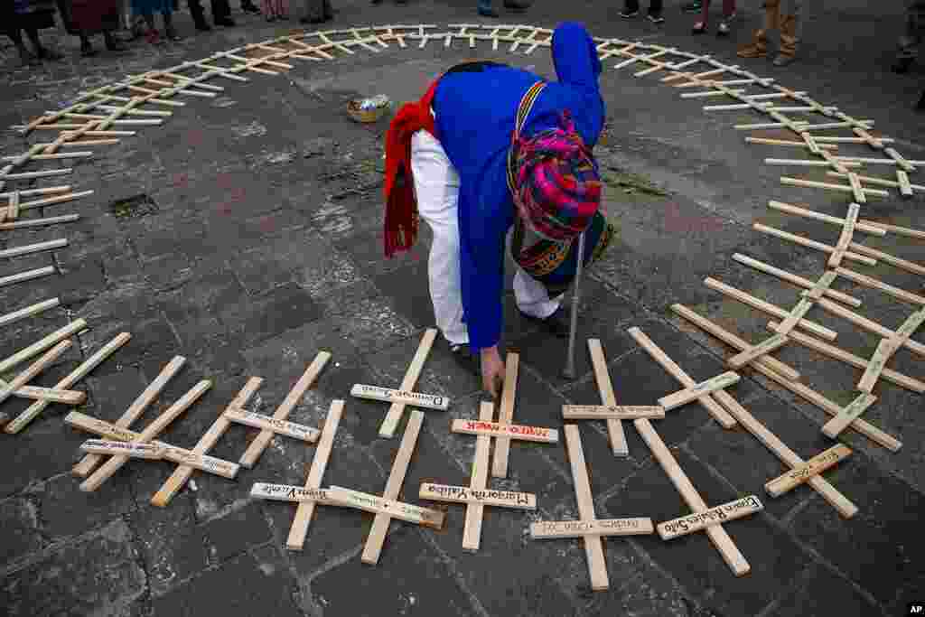 A Mayan spiritual guide arranges crosses with the names of people who died in the nation&#39;s civil war, which ended in 1996, in a circle for National Day of Dignity for the Victims of Armed Internal Conflict, at the National Palace in Guatemala City.