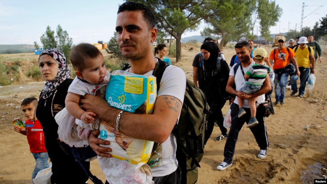 Syrian refugees walk toward a crossing point at Greece's border with Macedonia, near the Greek village of Idomeni, Sept. 8, 2015.