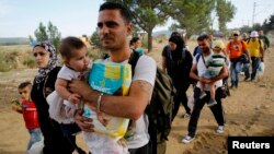 Syrian refugees walk toward a crossing point at Greece's border with Macedonia, near the Greek village of Idomeni, Sept. 8, 2015.