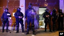 FILE - Riot police take position in front of a vacant bank occupied by squatters in Barcelona, Spain.