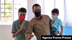 Handout picture released by the press office of Jorge Arreaza, showing him casting his vote along with his two sons during the re-run of the gubernatorial election in the state of Barinas, in Ciudad Tavacare, on the outskirts of Barinas, Venezuela, on Jan. 9, 2022.