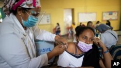 Una enfermera inocula a una maestra con una dosis de la vacuna Sinopharm COVID-19 durante una jornada de vacunación para el sector educativo en una escuela en el centro de Caracas, Venezuela. Marzo 25, 2021. Foto: AP.