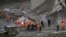 Members of National Disaster Response Force and State Disaster Response Fund carry the body of a victim after recovering it from the debris inside a tunnel during a rescue operation in Tapovan in Uttarakhand state, India, Feb. 14, 2021.