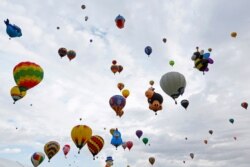 FILE - Hot air balloons fly during the 44th Albuquerque International Balloon Fiesta in Albuquerque, N.M., Oct. 4, 2015.