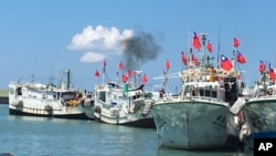 FILE - Taiwanese fishing boats flying national flags prepare to leave for the Taiwan-controlled Taiping Island from Taiwan's southern port city of Pingtung, Wednesday, July 20, 2016. (Central News Agency via AP)