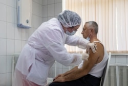 FILE - A Russian medical worker administers a shot of Russia's experimental Sputnik V coronavirus vaccine in Moscow, Russia, Sept. 15, 2020.