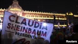 Personas sostienen una pancarta que dice "Claudia Sheinbaum presidenta" después de que el partido gobernante Morena de México la declarara ganadora de las elecciones presidenciales. En la Plaza del Zócalo en el centro de la Ciudad de México, México, el 2 de junio de 2024.