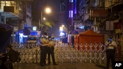 ဟောင်ကောင်မှာ အသွားအလာ ကန့်သတ် Lockdown လုပ်ထားတဲ့နေရာမှာ စောင့်ကြပ်နေတဲ့ ရဲတပ်ဖွဲ့ဝင်များ။ (ဇန်နဝါရီ ၂၄၊ ၂၀၂၁)