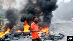 A Somali man protests against the killing Friday night of two people during an overnight curfew, intended to curb the spread of the new coronavirus, on a street in Mogadishu, Somalia, April 25, 2020.