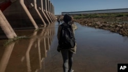 La migrante nicaragüense Aura Berrios camina con sus compatriotas cerca de la frontera entre EEUU y México, en Algodones, Baja California, México, el jueves 2 de diciembre de 2021.