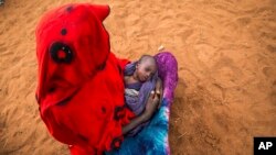 Une mère et son enfant attendent de la nourriture et de l'eau dans le district de Warder, une région somalienne de l'Ethiopia, le 28 janvier 2017. 