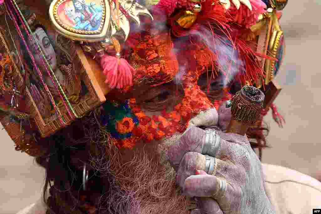 A sadhu (Hindu holy man) smokes marijuana using a &quot;chillum,&quot; a traditional clay pipe, as a holy offering during the Hindu festival Maha Shivaratri in Kathmandu, Nepal.