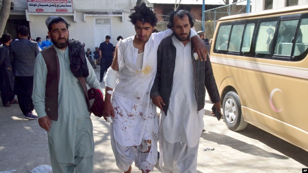 Seorang pria yang terluka akibat ledakan bom di stasiun kereta api berjalan dengan bantuan keluarganya di sebuah rumah sakit di Quetta, Pakistan barat daya, Sabtu, 9 November 2024. (Foto: AP)