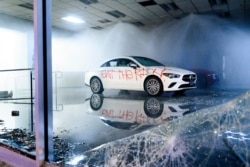 A vandalized car sits in a Mercedes-Benz of Oakland showroom in Oakland, Calif., May 30, 2020. The car was vandalized during a protest against the Monday death of George Floyd in police custody in Minneapolis.