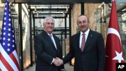 Menlu Turki, Mevlut Cavusoglu berjabatan tangan dengan Menlu AS, Rex Tillerson, kiri, dalam pertemuan di Istanbul, Minggu, 9 Juli 2017. Menlu AS, Rex Tillerson, menerima penghargaan dalam sebuah konferensi minyak global, di perusahaan para pengusaha minyak dan pemerintah otoriter di mana ia merintis karirnya (AP Photo)