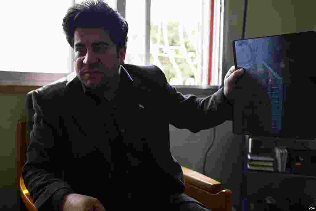 Yassar Oweir, who runs a private house for wounded Syrians in Amman, Jordan, holds up an x-ray of a wound he received during a protest last year in Dara, Syria. (Y. Weeks/VOA)