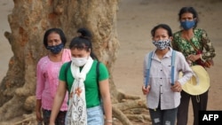 Para pengunjung kuil Angkor Wat di Siem Riep, Kamboja, menggunakan masker di tengah kekhawatiran merebaknya virus corona COVID-19, Jumat, 6 Maret 2020. (Foto: AFP)