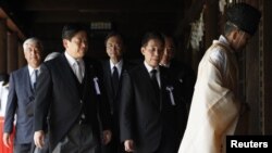 Japan's Land, Infrastructure, Transport and Tourism Minister Yuichiro Hata (2nd L) and other lawmakers are led by a Shinto priest after offering prayers to war dead at Yasukuni Shrine in Tokyo, August 15, 2012.