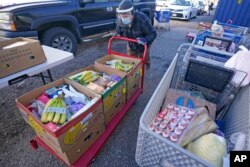 FILE - A volunteer loads food into cars outside Catholic Community Services of Utah, Nov. 20, 2020, in Ogden, Utah. As coronavirus concerns continue, the need for assistance has increased.