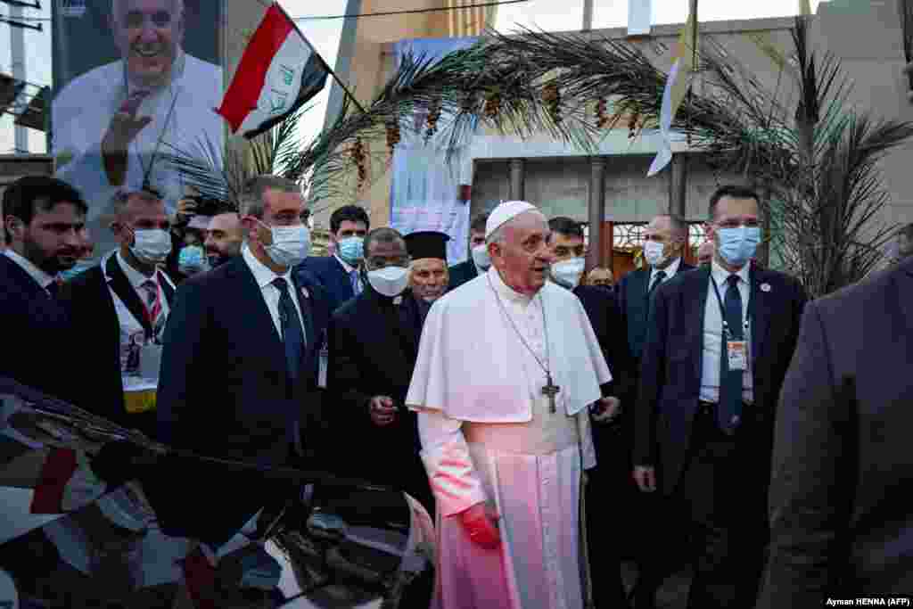 Walinzi wakiwa wamemzunguka Papa Francis wakati akiondoka kutoka Kanisa la Katoliki Baghdad la Sayidat al-Najat nchini Iraq on Machi 5, 2021.